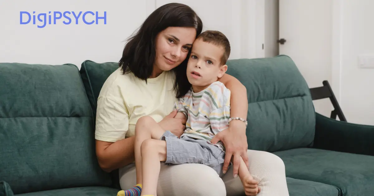 A woman gently holding a young boy on a green couch, both with calm expressions. The room is softly lit, conveying warmth and comfort. "DigiPSYCH" text is in the top-left corner.